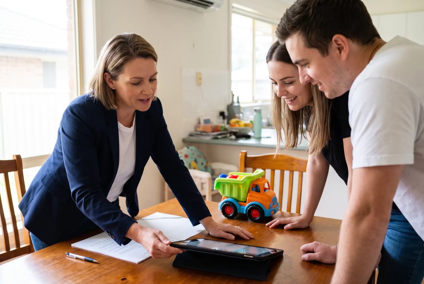 A broker talking a young couple through their options at their dining table